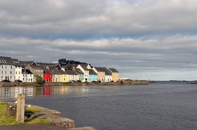 The painted houses of the Long Walk seen across the water at the Claddagh